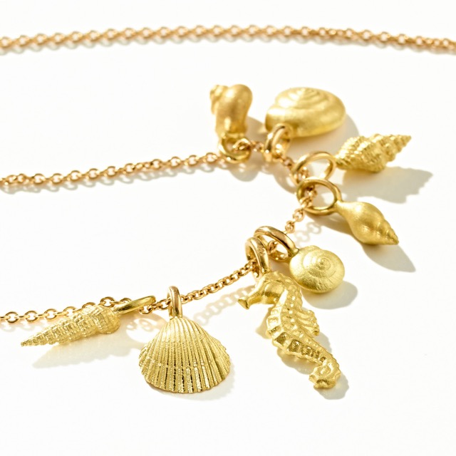 36) verschiedene Muscheln mit Seepferdchen, 750er Gelbgold.